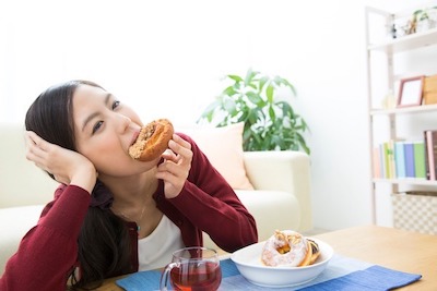 せたがや歯科室｜ブログ｜“ダラダラ食べ”は虫歯の原因に！｜間食をする女性の画像